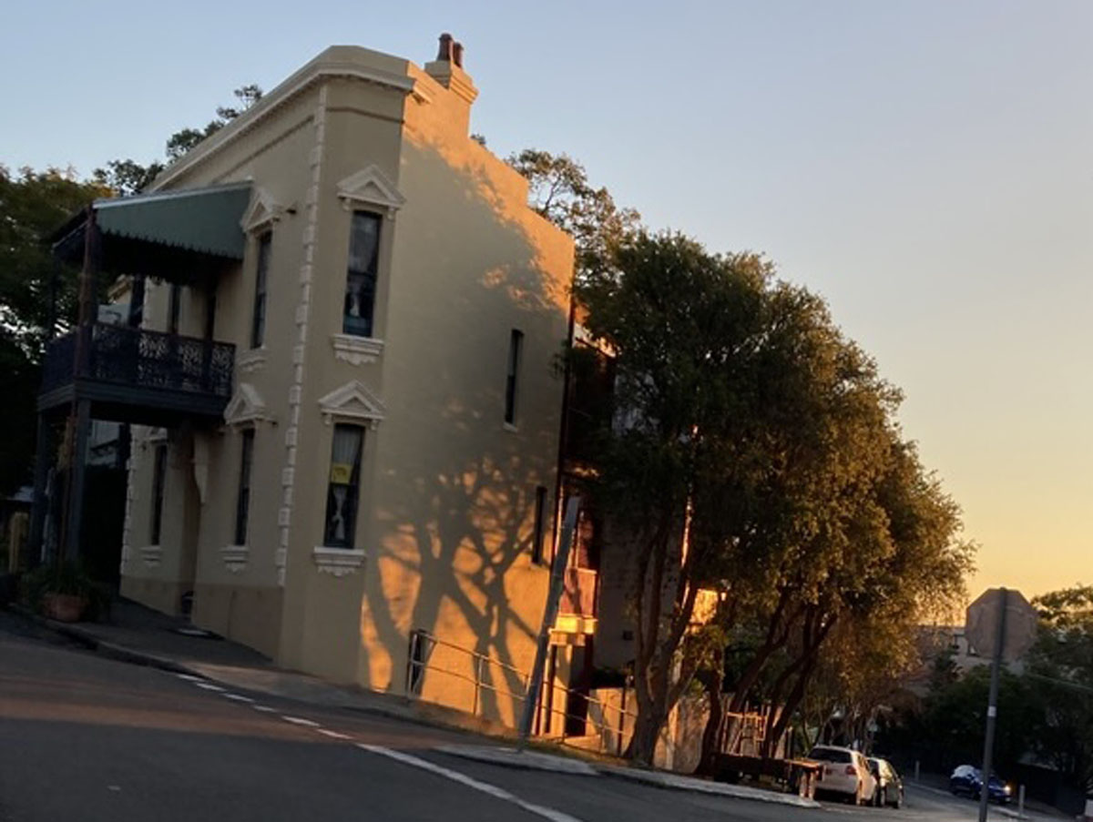 A two-storey corner terrace building in dusk light.