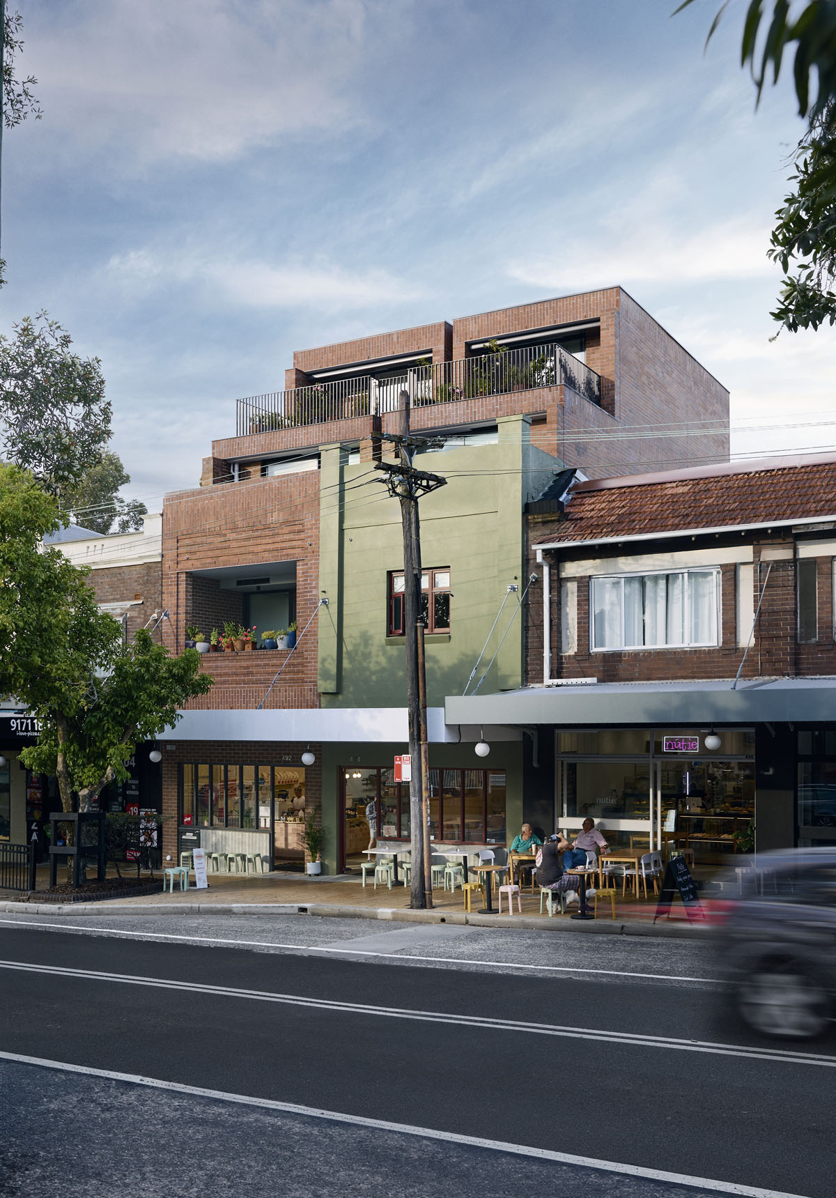 Shopfronts with modern shop-top apartment housing on an inner suburban main street.