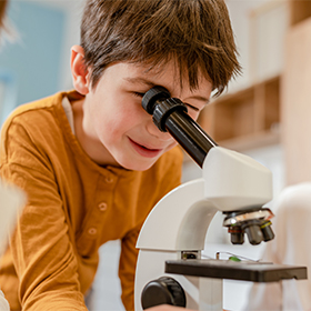 Boy looking through a microscope