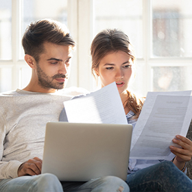 Couple sitting on couch reading formal letter