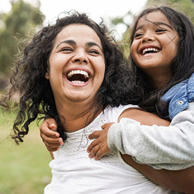 Happy mother having fun with her daughter outdoors