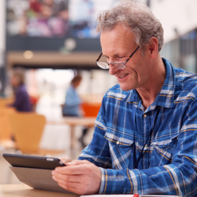 Man using a computer tablet in a library