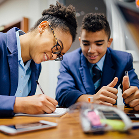 Two students in blue uniform studying together