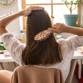 Young woman combing her hair