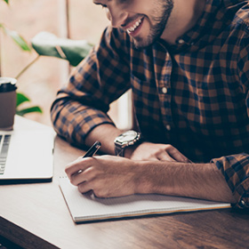 Young man writing on a notebook