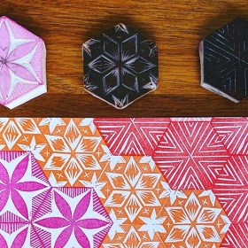 Block print stamps lie next to a colourful piece of paper