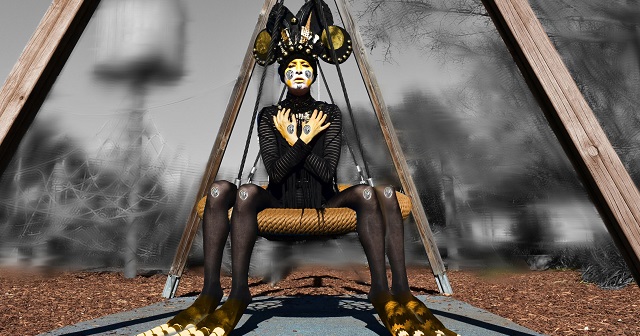 Photo of woman dressed as spider with black and yellow costume and face paint, black and gold large headdress, woman sits on a spider web swing in park with grey background 