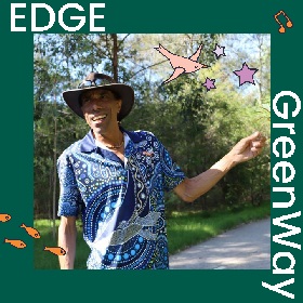 Photo of Terry Lennis on a path with greenery in the background. Terry wears an Akubra hat and a blue t-shirt with Aboriginal artwork on it