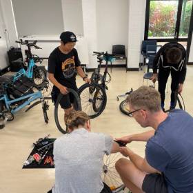 4 people working on bike parts