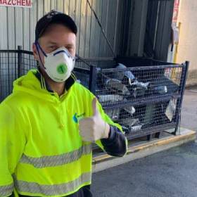 Man in high vis vest in front of recycling collection