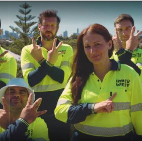 Two men in hi vis clothes with hands out in rap gestures