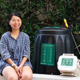 Smiling woman sitting next to compost bin