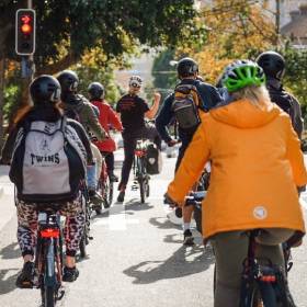 Group of people cycling up the road (taken from behind)