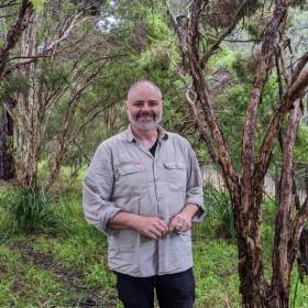 Man smiling standing in bushland