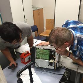 Two men pulling apart a computer