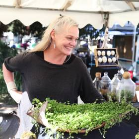 Woman standing at stall with plants