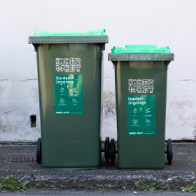 Two green rubbish bins with green garden organics labels on them