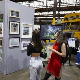 Two women standing in front of art hanging on a wall