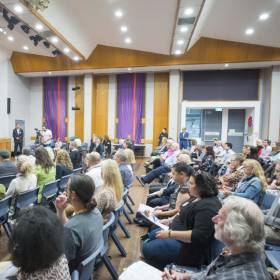 Group of people in a hall looking at the stage