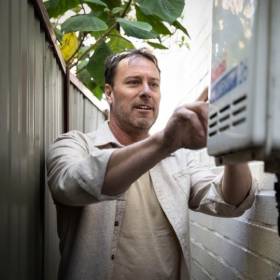 man inspecting hot water system