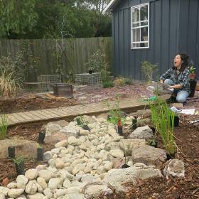 Woman in backyard making a garden with lots of rocks