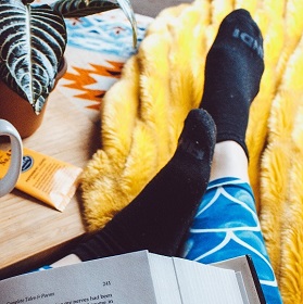 Feet in socks resting on yellow rug