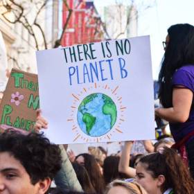 Group of people at a rally holding up a sign saying "There is no planet B"