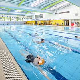 50m pool at AKAC with person wearing orange swimming cap doing freestyle laps