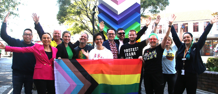 Inner West COuncillors and staff holding the Pride Progress flag in front of a rainbow beacon in Pride Square