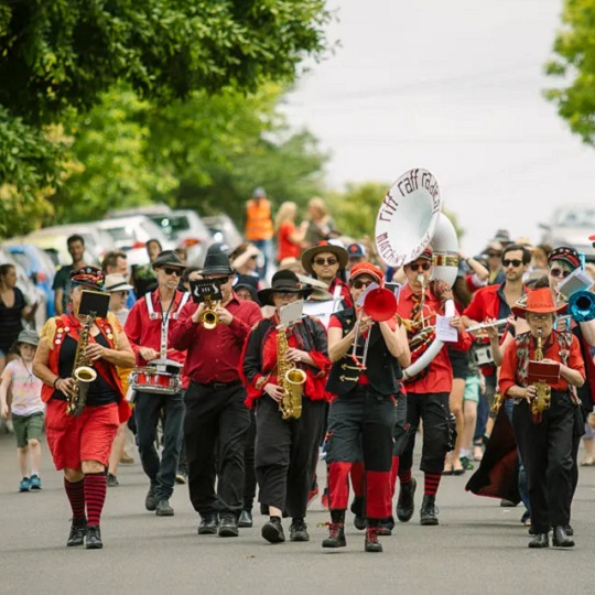 Brass band in red and black unform playing in the street