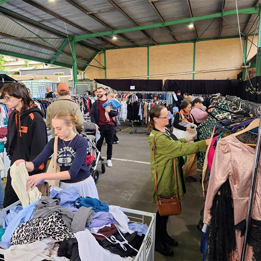 people browsing second hand clothes at an indoor market