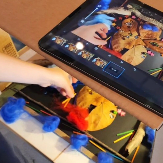 close up of kids hands making animation using puppets and an ipad.