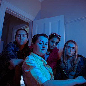 a blue tint photo of 4 people in front of a door