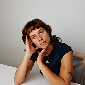 A woman looking pensive reclining on a desk