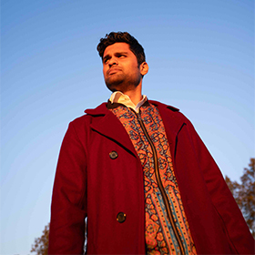 A man imn a red jacket against a blue sky