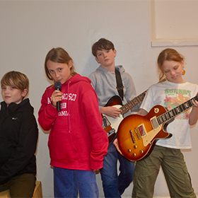 a group of 4 young kids with instruments