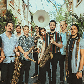 A group of musicians standing in a laneway