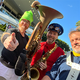 3 men holding a sousaphone