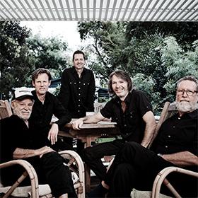 A blakc and white photo of four guys under an awning