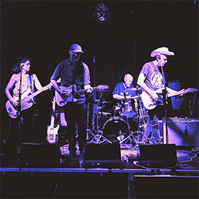 A blue tint photo of a band on stage