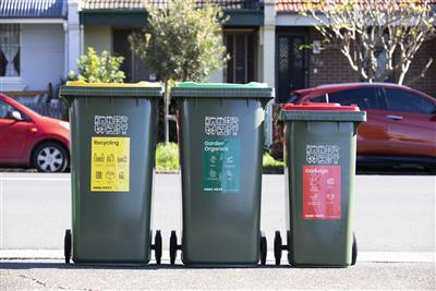 image of three Council bins yellow, green and small red bin on a footpath