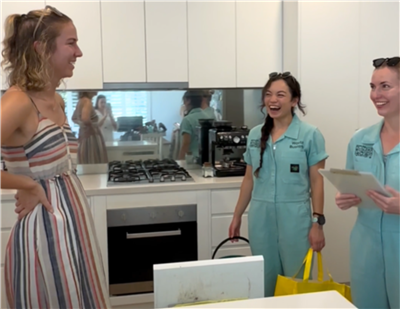 Waste busters speak to a resident in their kitchen