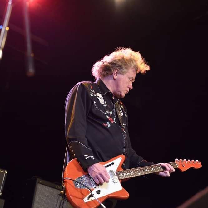 A man playing a guitar on stage