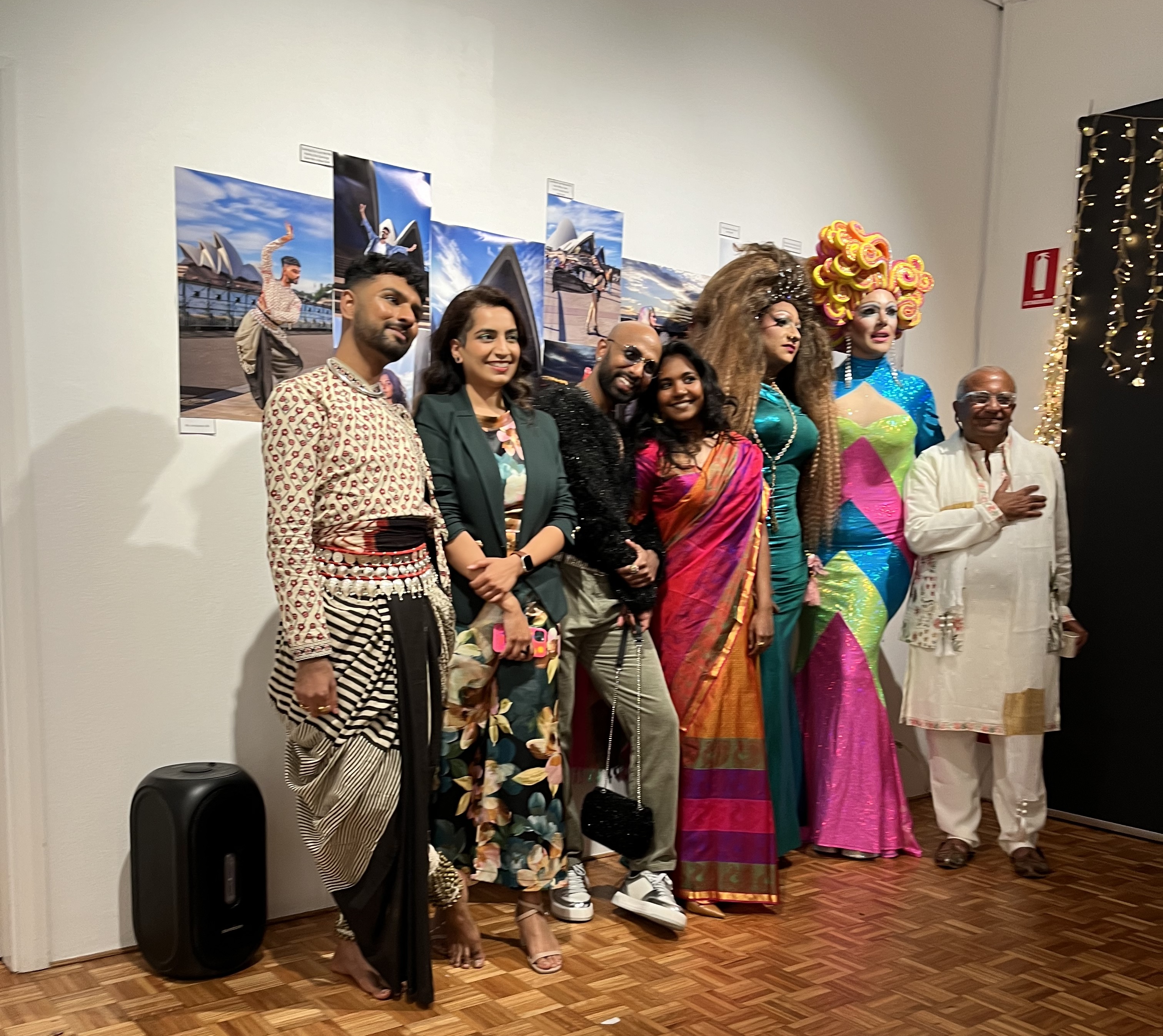 Satrang group photo, performers and artists pose in front of the photos they appear in