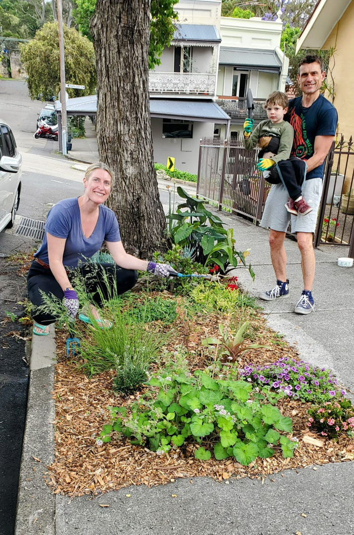 A couple with a child tending to a verge garden.