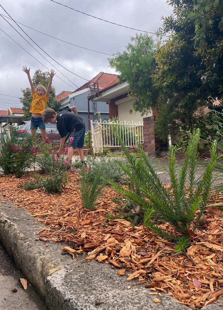 Two children tending to a verge garden.