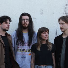 Four people against a concrete backdrop.