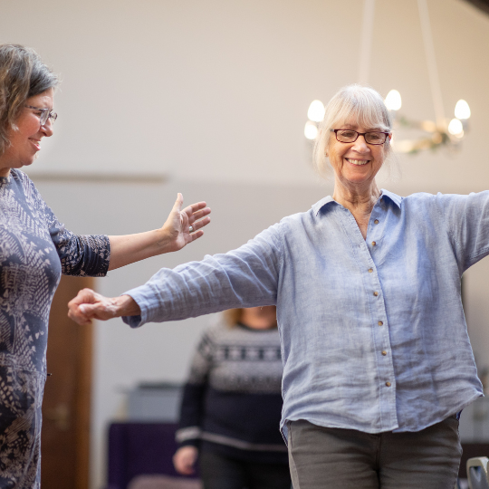 An older person performing a walking balance exercise.