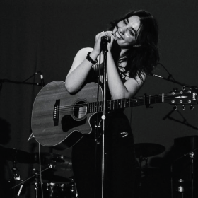 Black and white photo of singer AJ Stanton with guitar