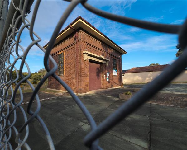 a photo from a wire fence holes of a brick building